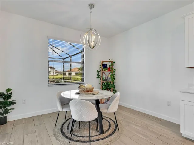 Dining room with wood tiled floors and suspended lighting
