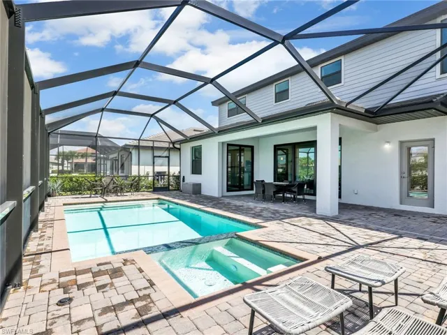 Integrated pool / spa with a sunroom, a patio, a lanai, and outdoor dining space