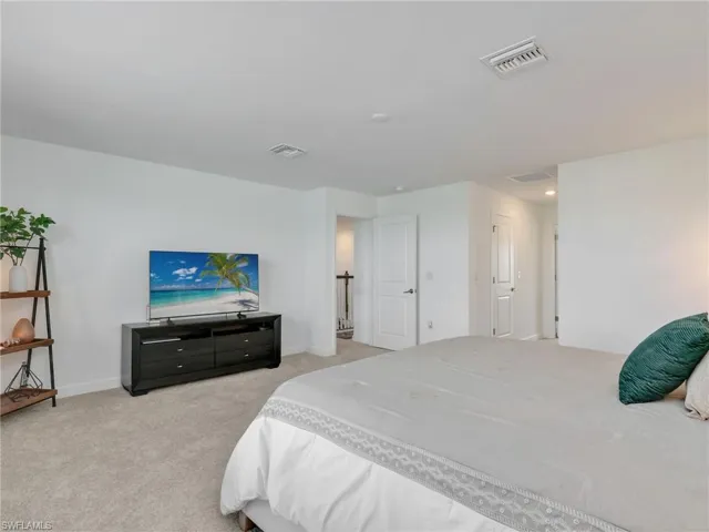 Bedroom featuring light colored carpet and baseboards