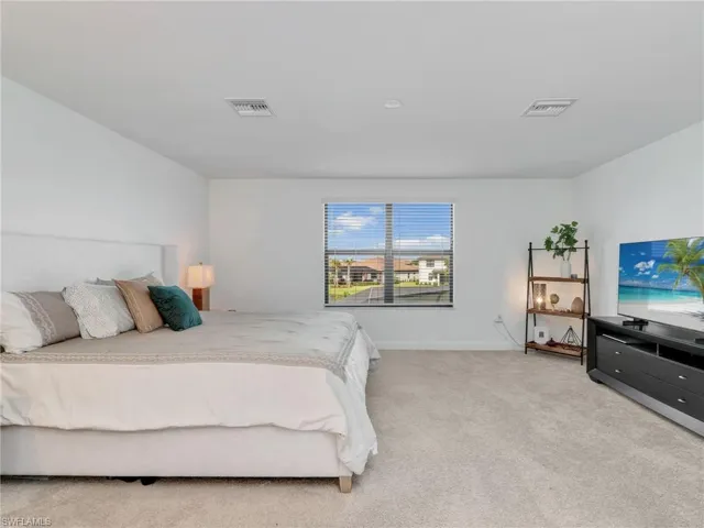 Bedroom featuring light colored carpet and baseboards