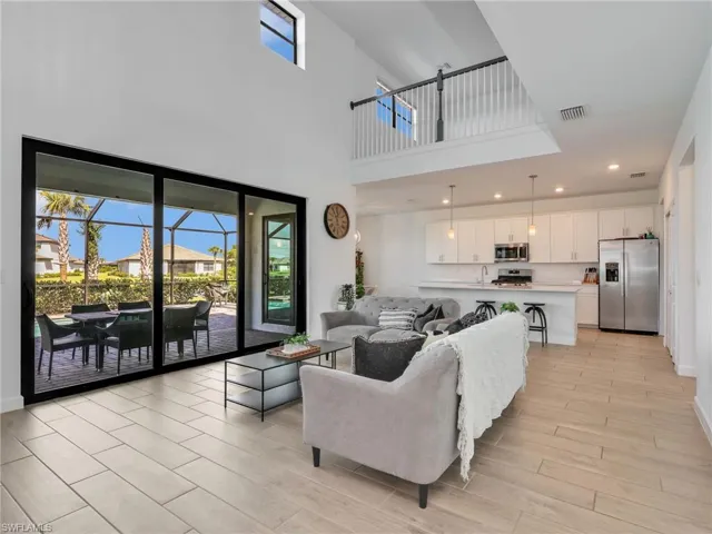 Living room with wood tiled floors, recessed lighting, and a high ceiling