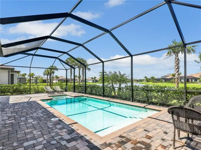 Integrated pool / hot tub featuring a sunroom, a residential view, a lanai, and a patio area