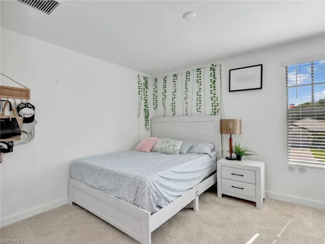 Bedroom featuring baseboards and light carpet