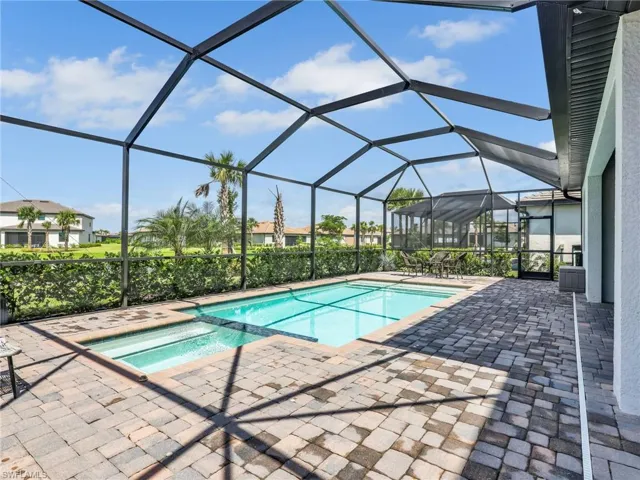Integrated pool / spa with a sunroom, a patio, and glass enclosure