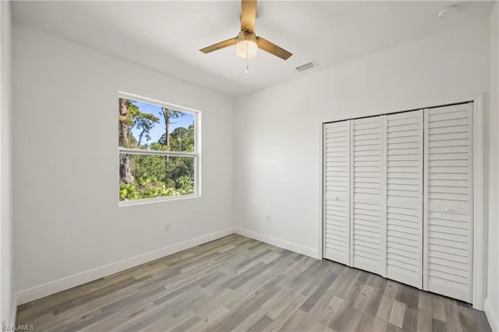 Unfurnished bedroom featuring ceiling fan, light wood-type flooring, and a closet
