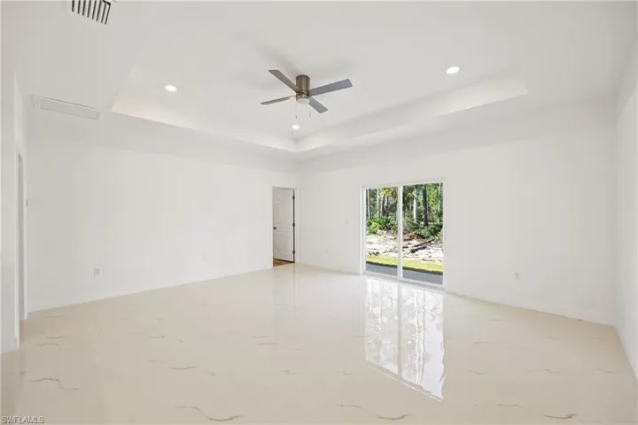 Unfurnished room featuring a raised ceiling and ceiling fan