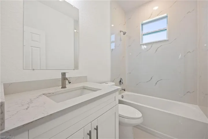 Full bathroom featuring vanity, toilet, and shower / bath combination