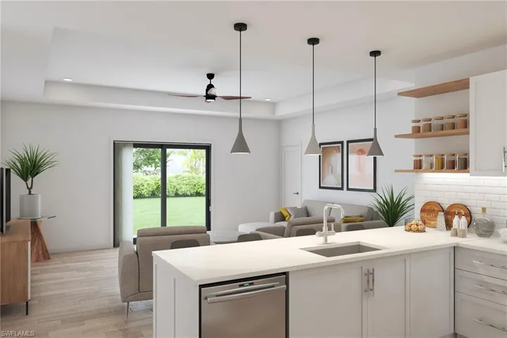 Kitchen featuring white cabinets, light hardwood / wood-style floors, a raised ceiling, and sink