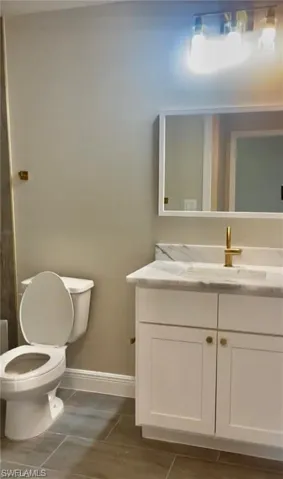 Bathroom featuring tile flooring, vanity, and toilet
