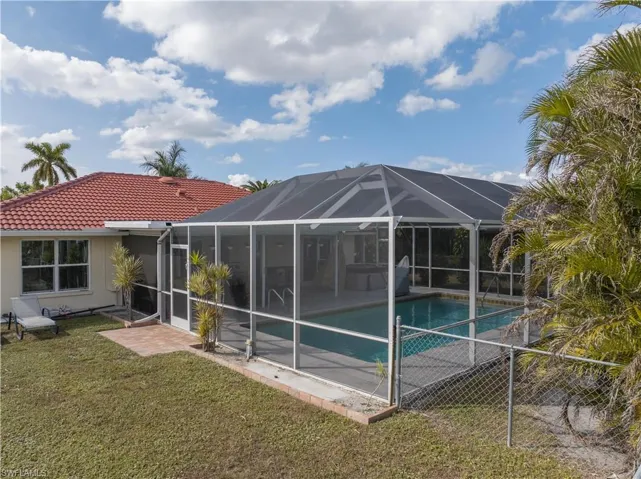 Back of property with a yard and glass enclosure