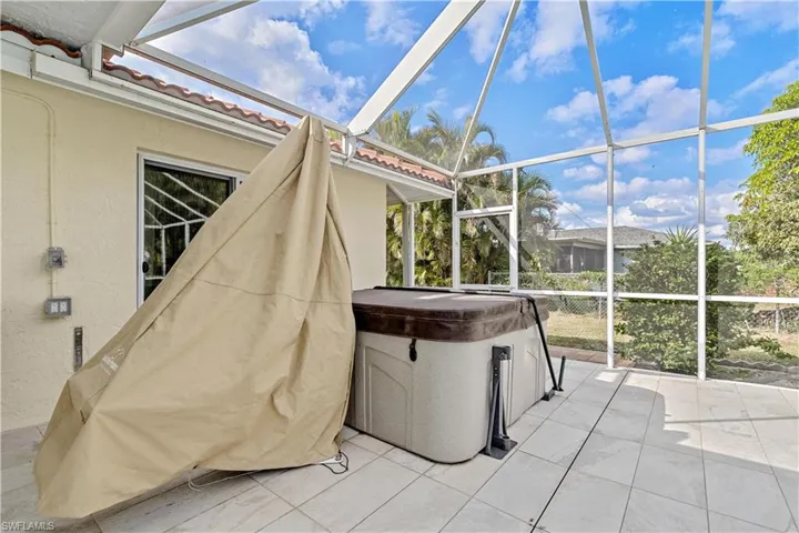Unfurnished sunroom featuring a hot tub