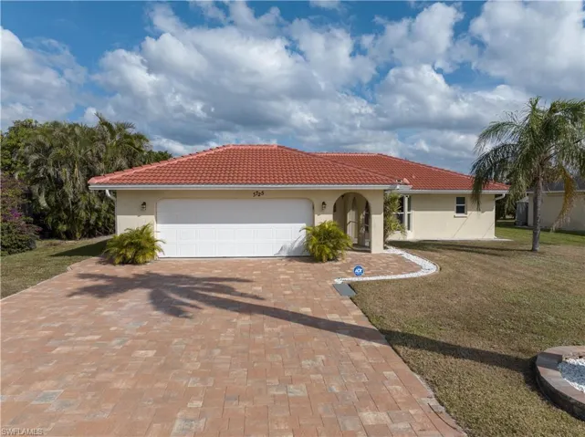 Mediterranean / spanish house with a front lawn and a garage
