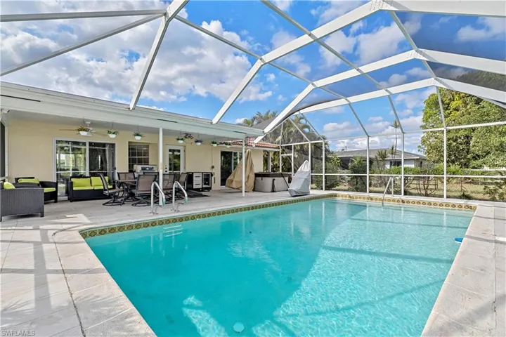 View of swimming pool with a lanai, an outdoor living space, ceiling fan, a patio, and a hot tub