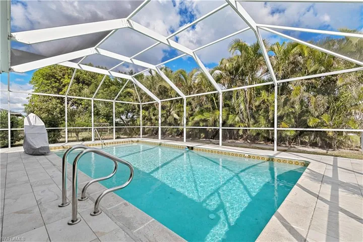 View of pool featuring a patio area and glass enclosure