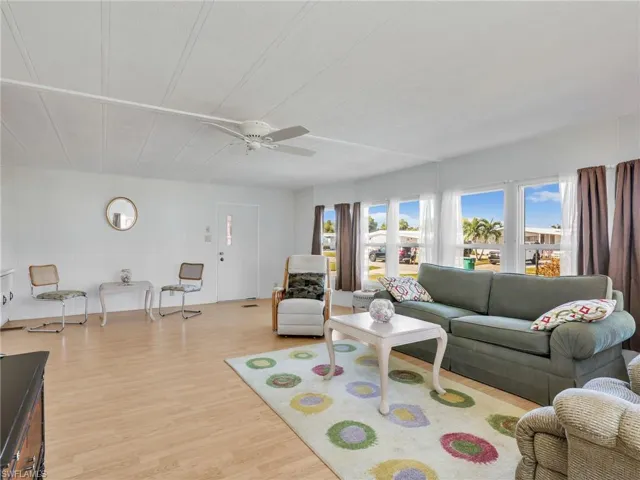 Living area with light wood finished floors and a ceiling fan