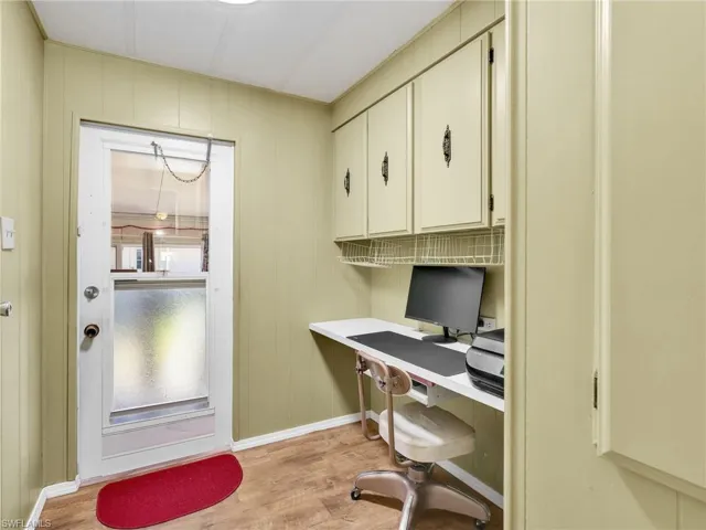 Home office featuring light wood-style floors and wooden walls