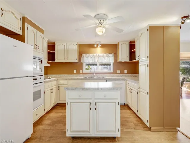 Kitchen featuring open shelves, white appliances, light countertops, and a kitchen island