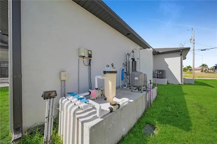 View of side of property featuring stucco siding, a yard, and a patio
