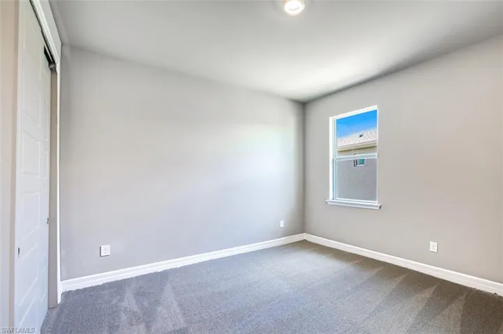 Spare room featuring dark colored carpet