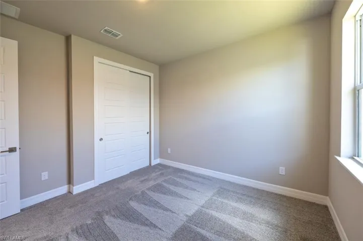 Unfurnished bedroom with carpet and a closet