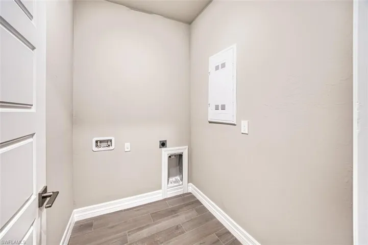 Laundry area with hookup for a washing machine, electric dryer hookup, and hardwood / wood-style floors