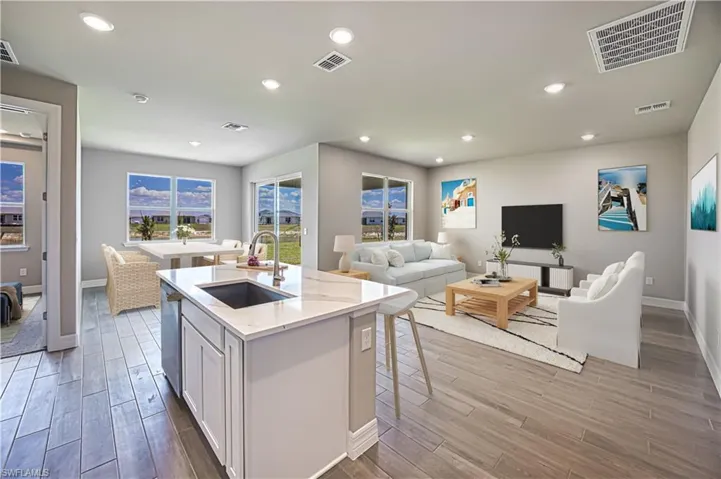 Virtual Stage Kitchen featuring a center island with sink, dishwasher, sink, white cabinets, and a kitchen bar