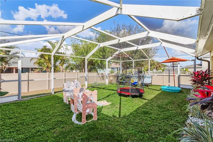 Fenced backyard featuring a sunroom and glass enclosure
