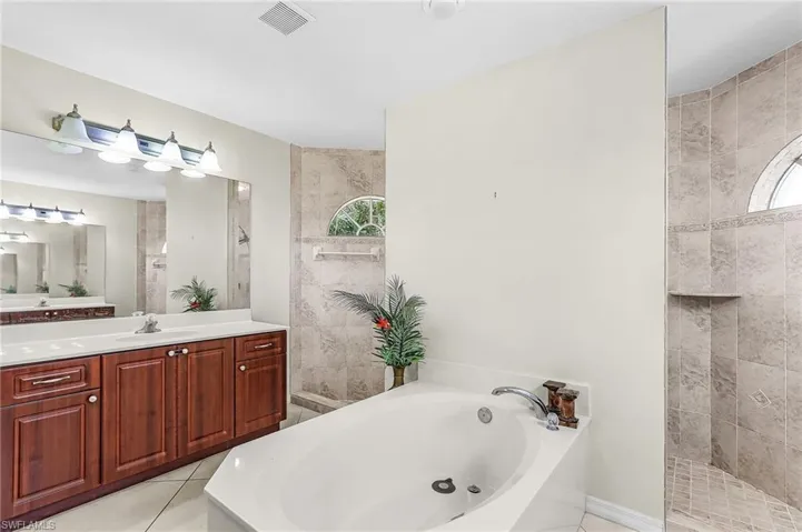 Full bathroom featuring vanity, a garden tub, and a walk in shower