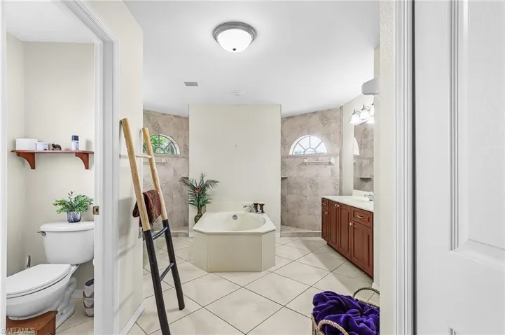 Full bathroom with walk in shower, vanity, light tile patterned flooring, and a bath