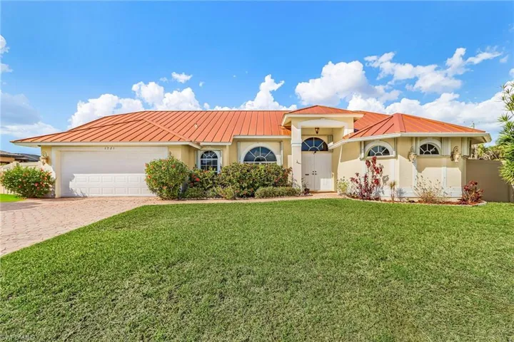 Mediterranean / spanish-style home with a garage, driveway, stucco siding, and a front yard