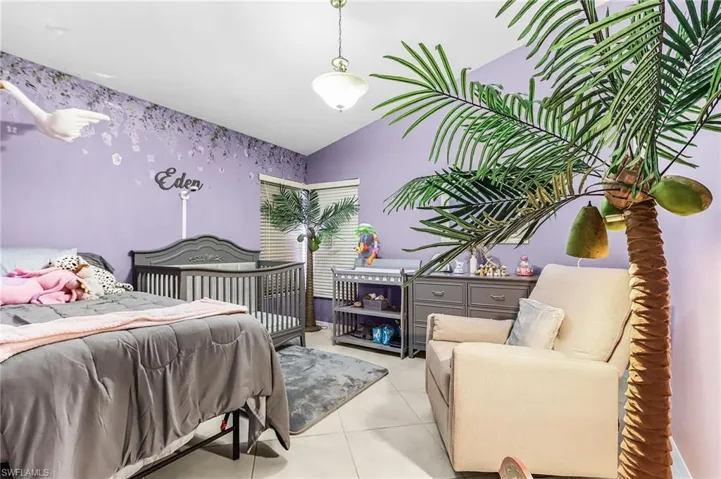 Tiled bedroom featuring lofted ceiling