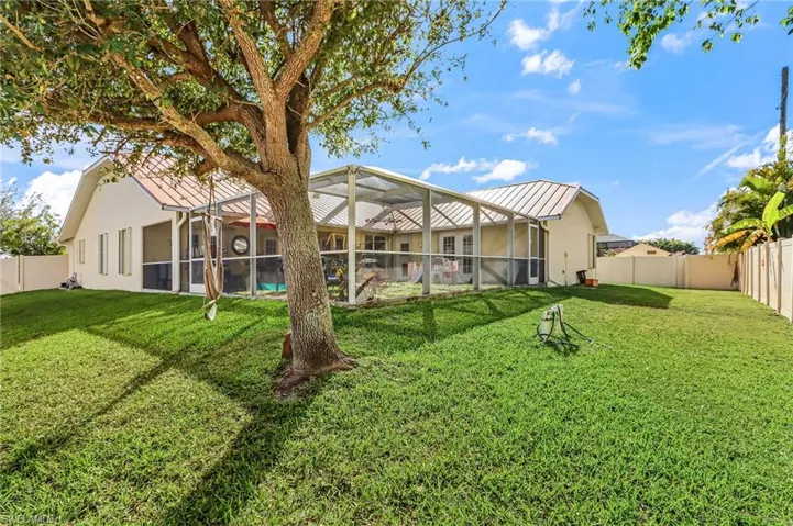 Back of house featuring glass enclosure, a sunroom, a fenced backyard, and an outdoor pool