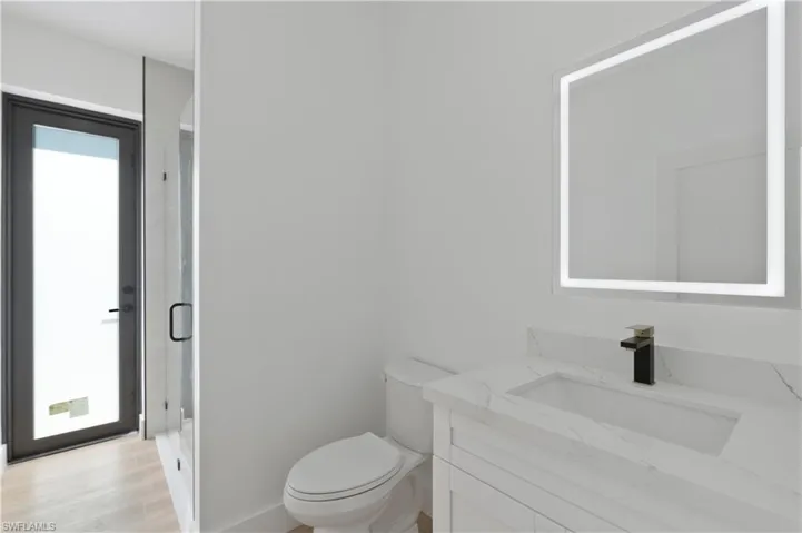 Bathroom with vanity, a stall shower, plenty of natural light, and light wood-style floors