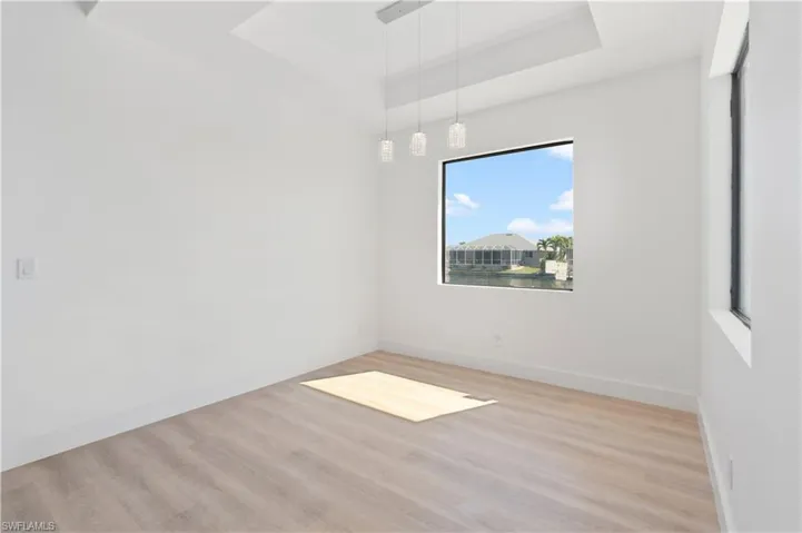 Empty room featuring light wood-style flooring and a raised ceiling