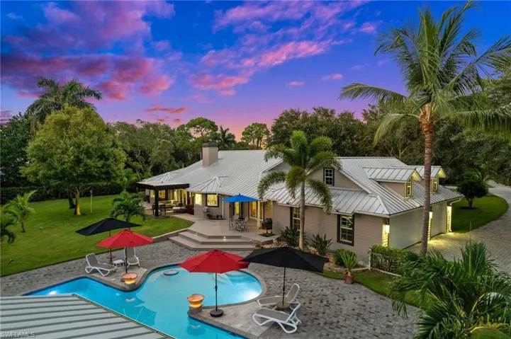 View of rear of home, resort style pool area and garages