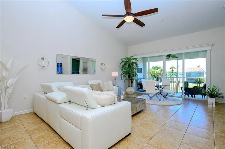 Spacious Living area featuring light tile patterned flooring, high vaulted ceiling, and modern ceiling fan