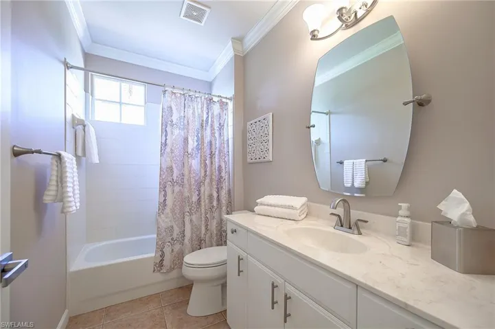 Full bathroom with shower / bath combo, vanity, crown molding, and light tile patterned floors