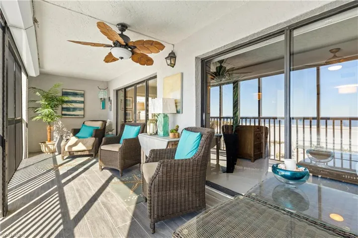 Sunroom featuring ceiling fan and a water view