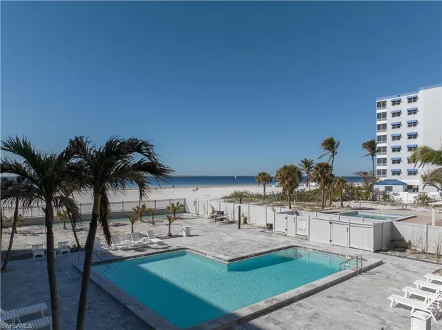 View of swimming pool with a water view and a patio area