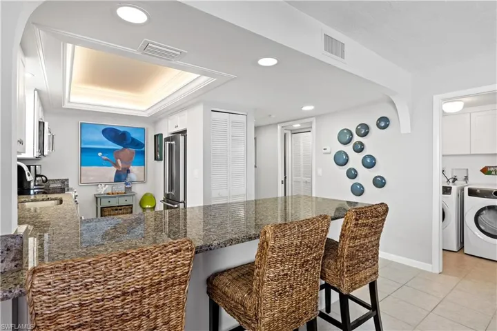 Kitchen with white cabinets, sink, a breakfast bar area, kitchen peninsula, and stainless steel appliances
