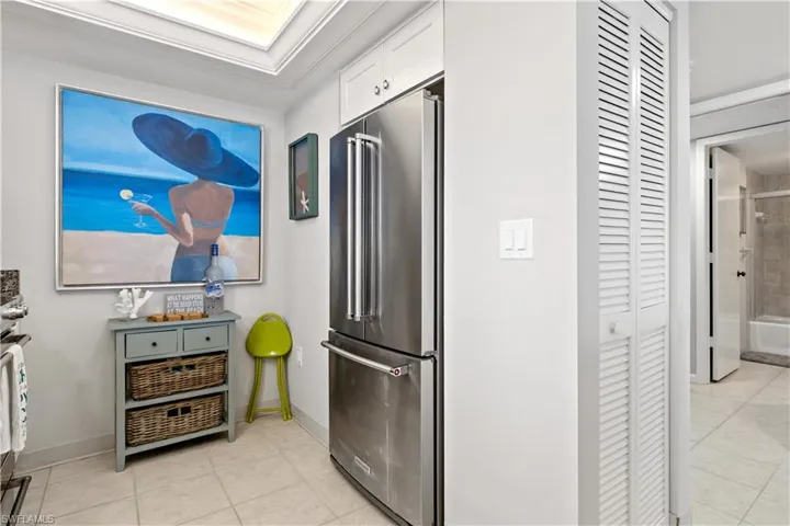 Kitchen with white cabinets, high quality fridge, and light tile patterned flooring