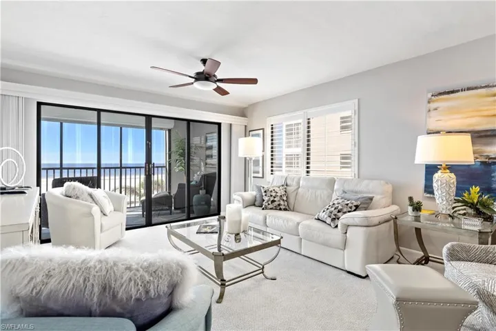 Carpeted living room featuring a water view and ceiling fan