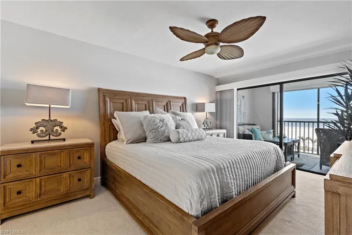 Carpeted bedroom featuring ceiling fan and access to outside