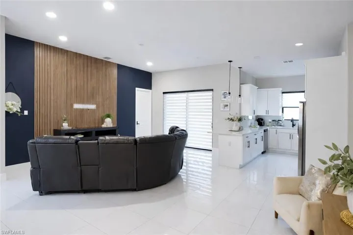 Living area featuring healthy amount of natural light, an accent wall, recessed lighting, light tile patterned floors, and wooden walls