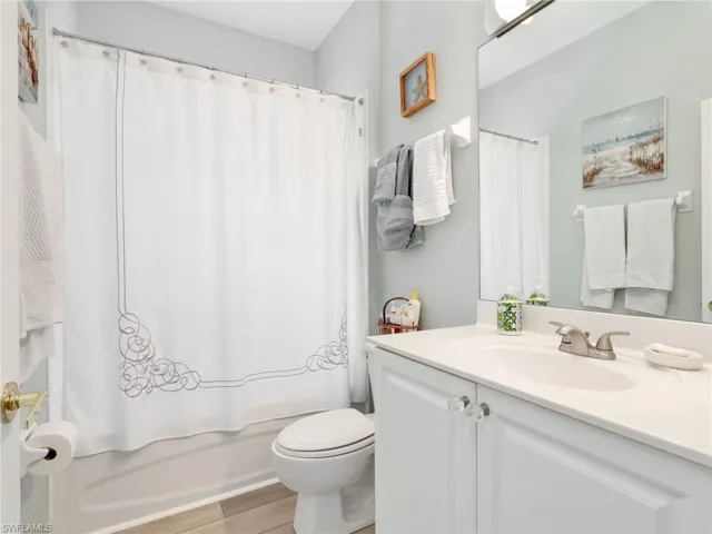 Bathroom featuring a white vanity with crystal knobs, an integrated sink, and a brushed nickel faucet