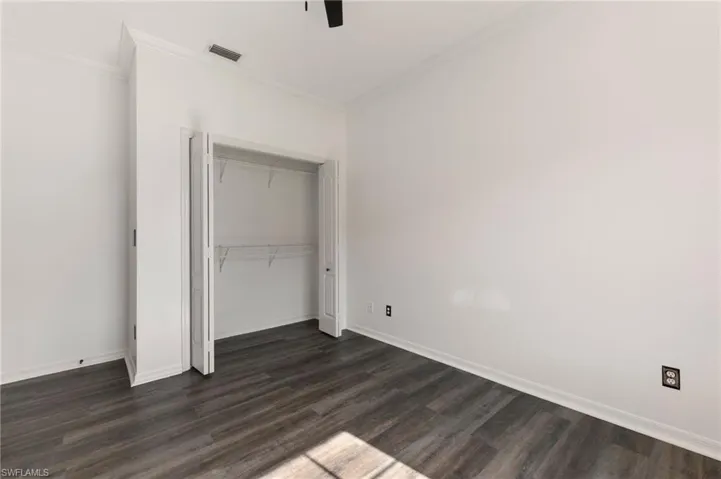 Interior space featuring wood-finish flooring, white baseboards, and white walls
