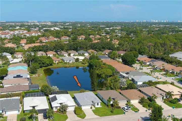 Lakeside property featuring mature landscaping and a well-maintained lawn