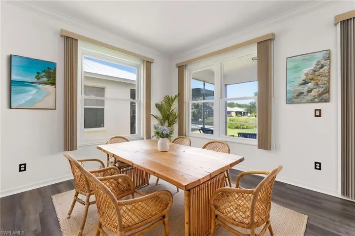 Dining space featuring white walls and crown molding
