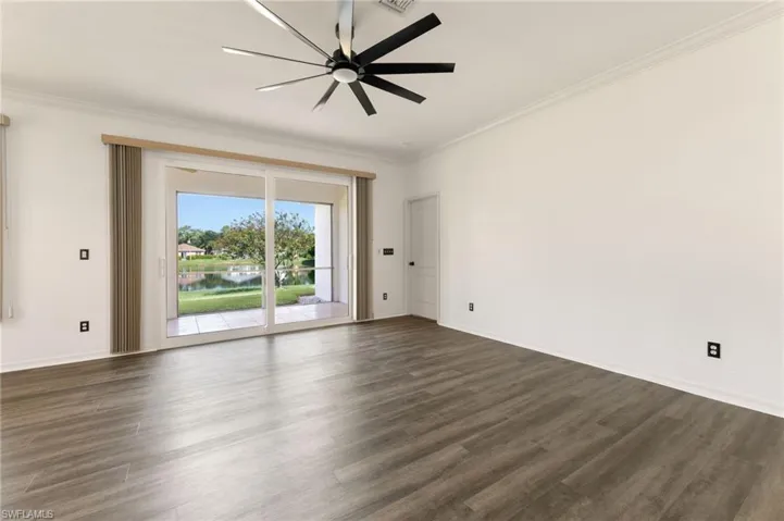 Spacious interior featuring wood-finish flooring, white walls, and crown molding