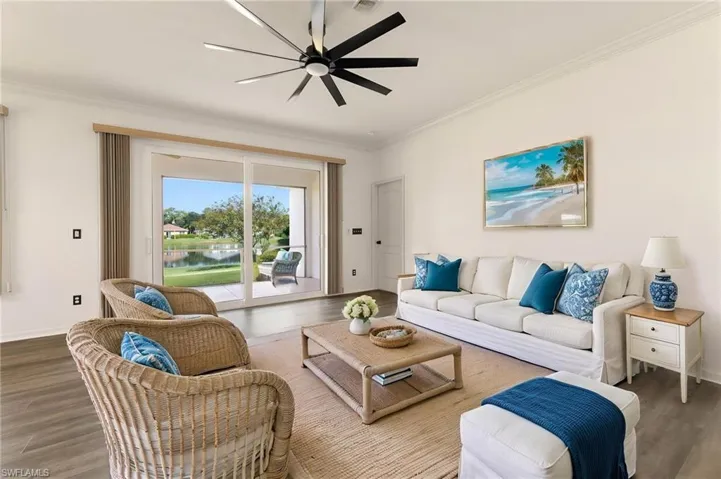 Spacious living area featuring wood-finish flooring, a contemporary ceiling fan, and crown molding